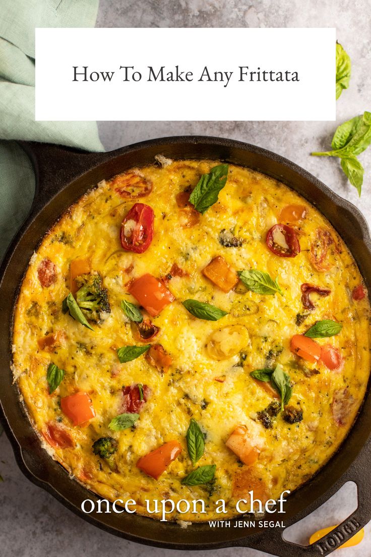 an omelet with tomatoes, basil and cheese in a cast iron skillet