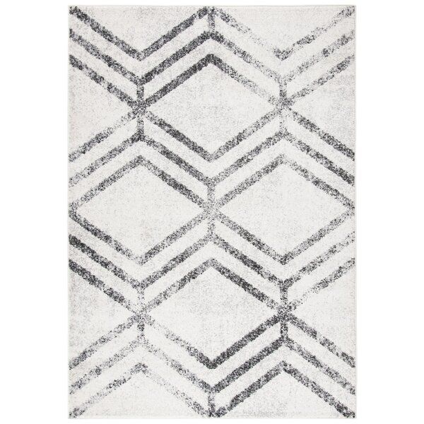 a white rug with black and grey lines on it, in the shape of an abstract diamond