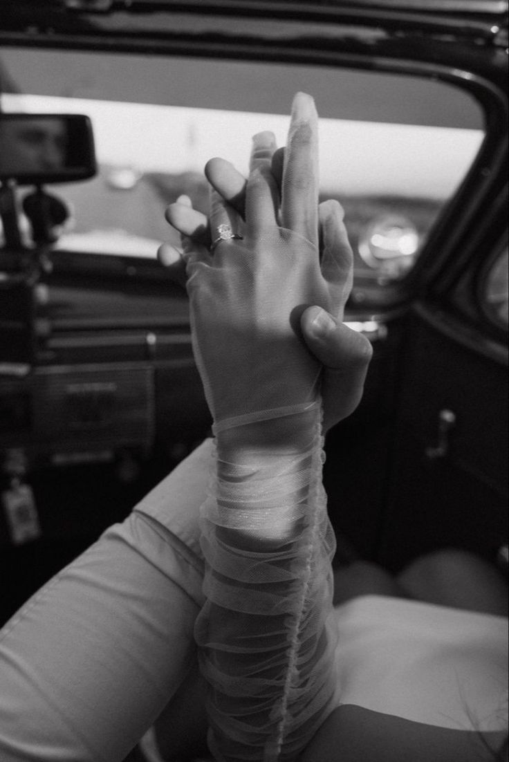 a woman holding her hand up in the back seat of a car