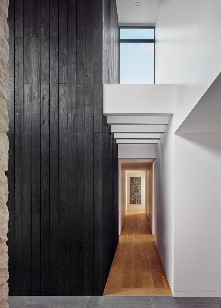 the hallway is lined with black wood and white walls