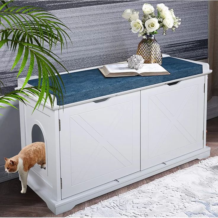 an orange and white cat standing on top of a dog house next to a potted plant