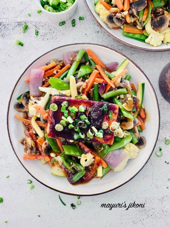 two plates filled with vegetables on top of a table