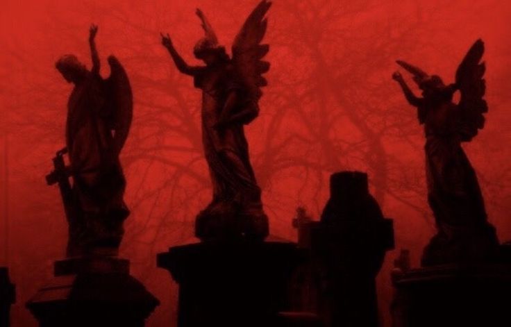 three statues in front of a red sky with trees behind them and foggy skies