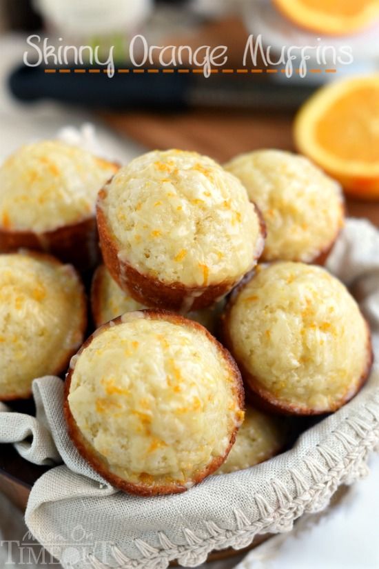 orange muffins in a basket on a table