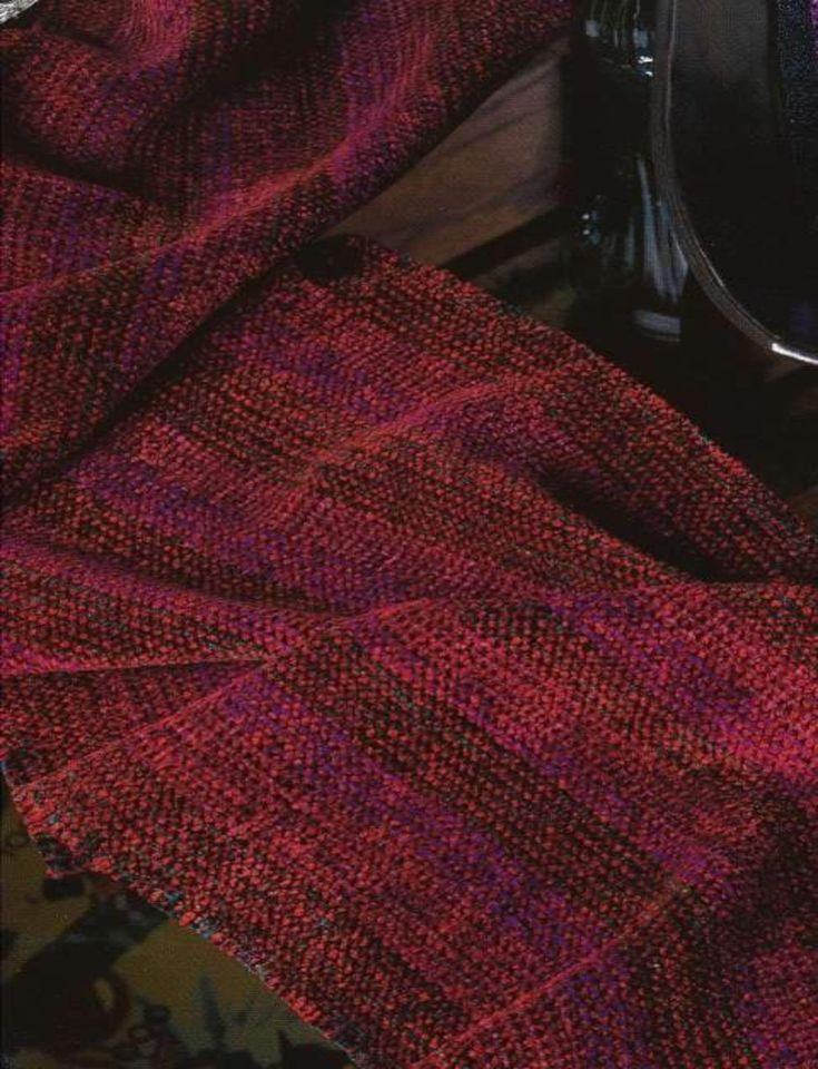 a red blanket sitting on top of a wooden table