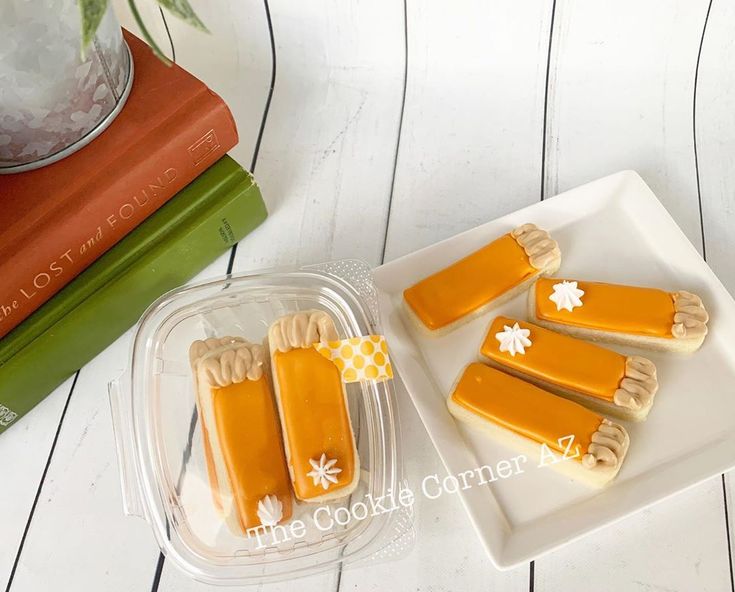 four pieces of banana pops sitting on top of a white plate next to a stack of books