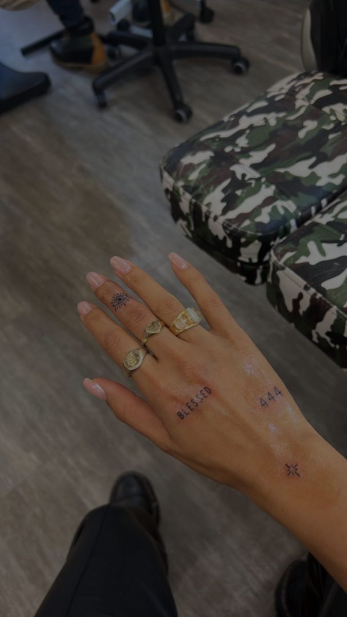 a woman's hand with two rings on it and the word love tattooed on her left wrist