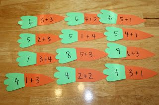 several pieces of paper with numbers on them sitting on a wooden floor in front of a pair of scissors