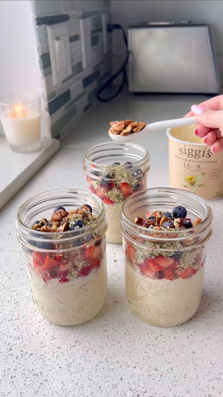 three jars filled with food sitting on top of a counter