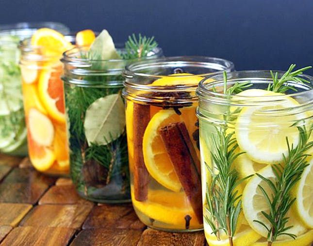 several mason jars filled with lemons and herbs