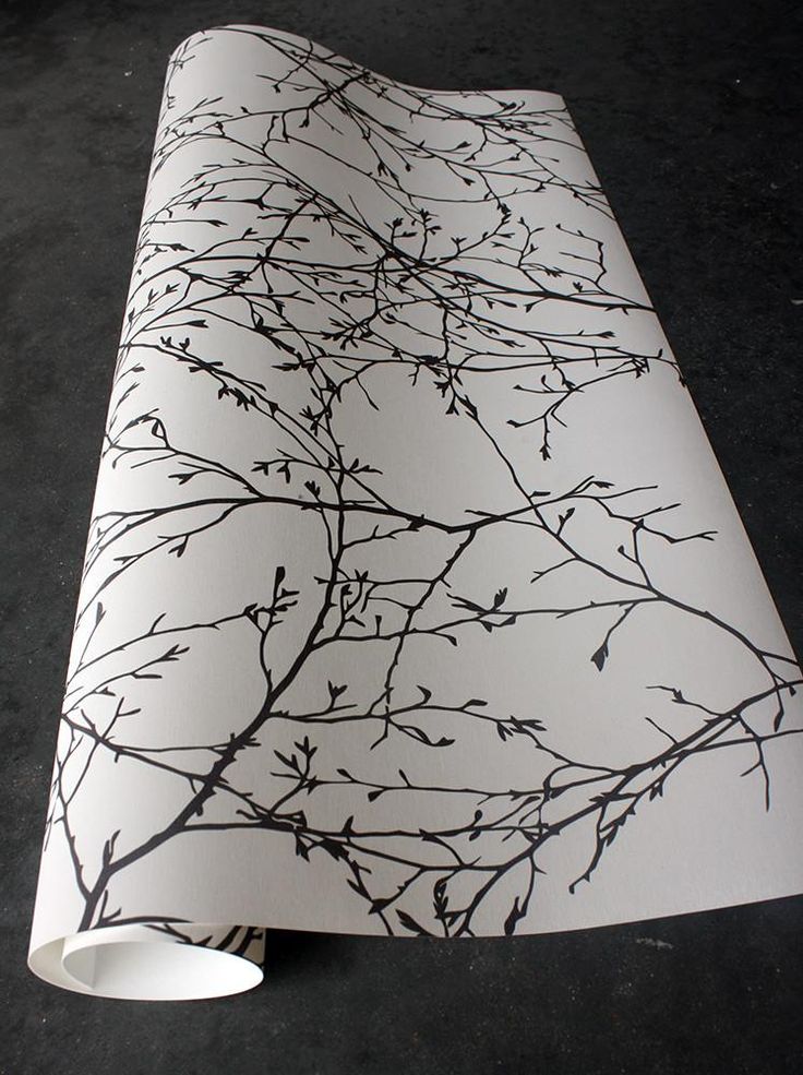 a white and black wallpaper with branches drawn on it's side by itself