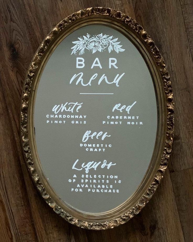 a close up of a mirror on a wooden wall with writing on it that says bar menu