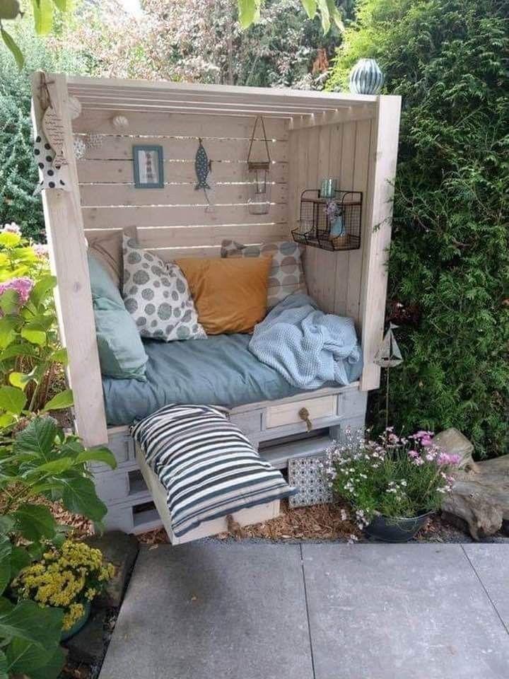 a bed made out of an old pallet is sitting in the middle of a garden