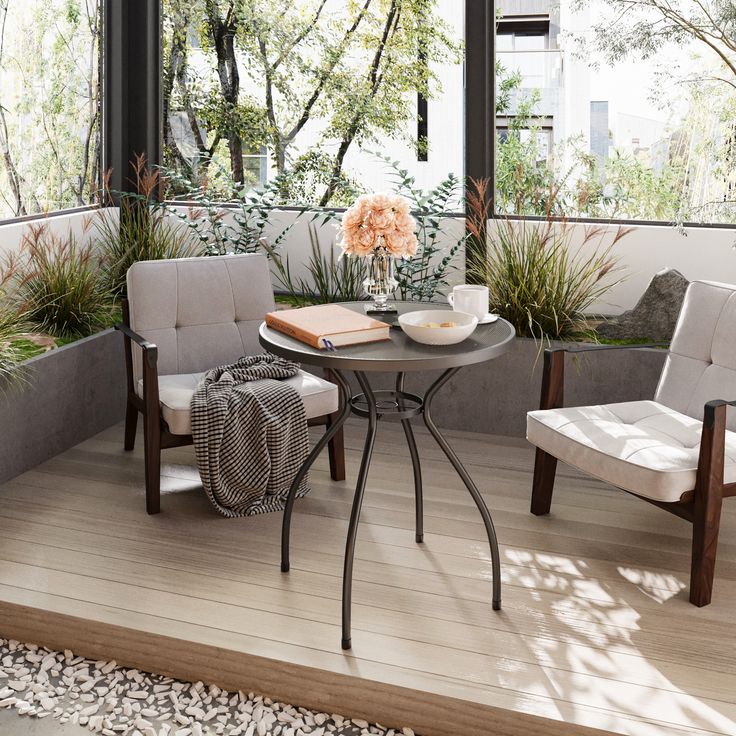 two chairs and a table on a deck with flowers in vases next to them