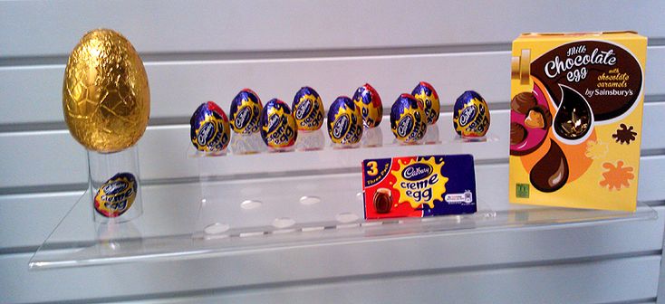 chocolate eggs and candy are on display in a store window, along with an egg box