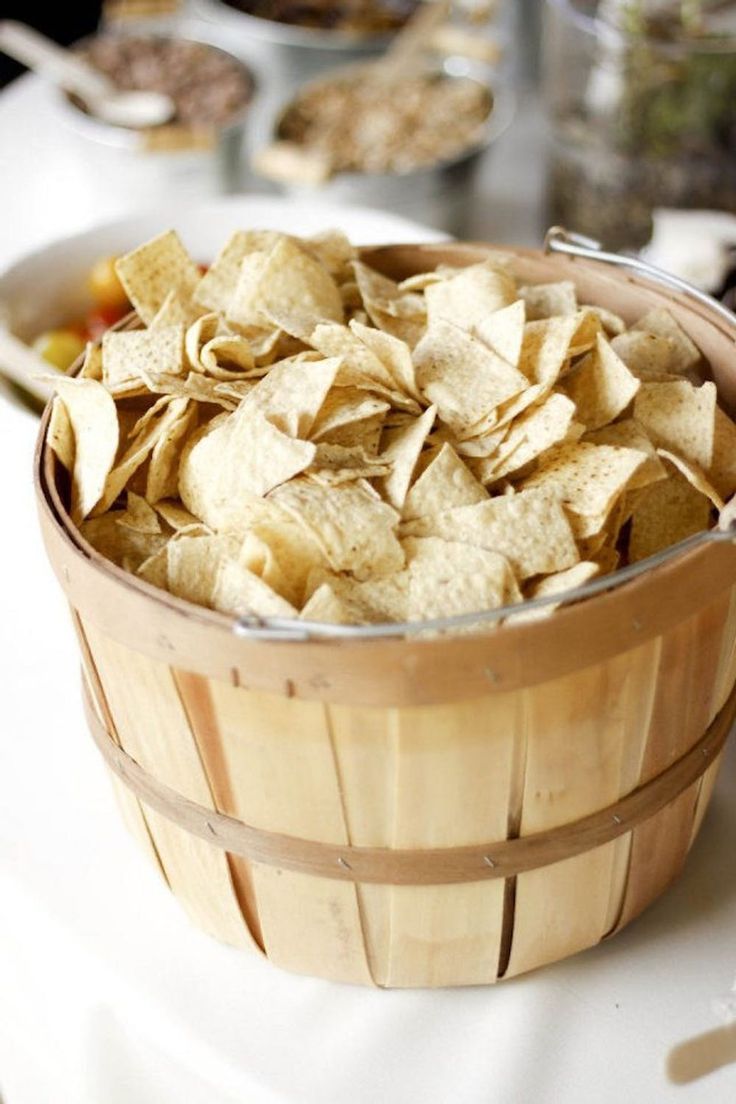 a wooden basket filled with chips on top of a table