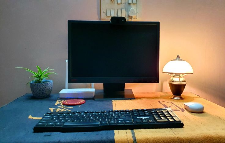 a computer monitor sitting on top of a desk next to a keyboard