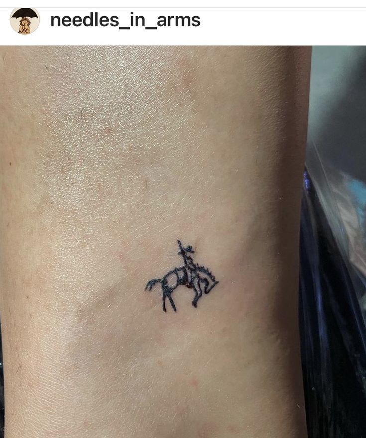 a small black horse tattoo on the side of a woman's neck and leg