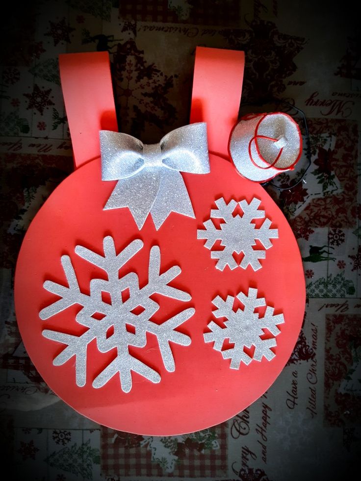 a red christmas ornament with snowflakes on it