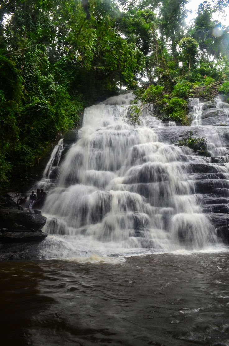 a large waterfall with lots of water coming out of it's sides in the jungle