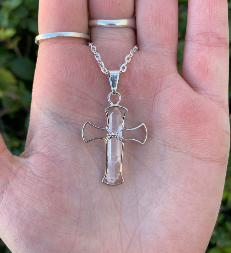 This listing is for one clear quartz cross necklace. Quartz is a transparent stone that is colorless but can also have a milky hue. It is typically found in crystal form either as a crystal point, or still attached to its matrix. It was discovered in ancient times. Quartz translates from German to mean hard. Quartz is a stone that helps amplify other stones and is often referred to as a universal crystal. It helps to clear the mind and bring tranquility and peace. This stone is said to bring the Spiritual White Cross Jewelry, Wire Wrapped Cross Jewelry For Gift, Spiritual Clear Quartz Jewelry, Spiritual Wire Wrapped Cross Pendant Necklace, Spiritual Style Clear Wire Wrapped Jewelry, Spiritual Wire Wrapped Crucifix Jewelry, Spiritual Clear Jewelry Gift, Spiritual Clear Jewelry For Gifts, Spiritual Style Clear Jewelry For Gift