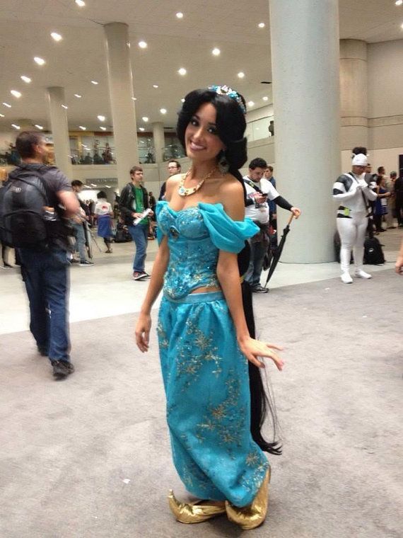 a woman in a blue dress is posing for the camera with her hand on her hip