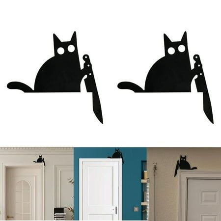 two black cats sitting on top of each other in front of a door and another cat behind the door