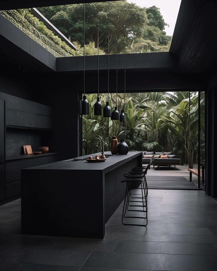 an open kitchen with black counter tops and stools