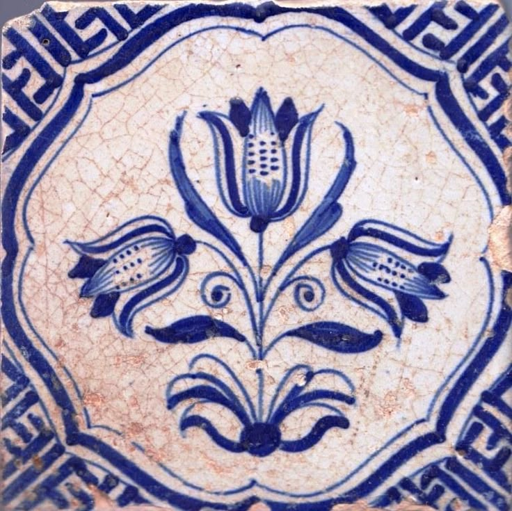 a blue and white tile with flowers on it