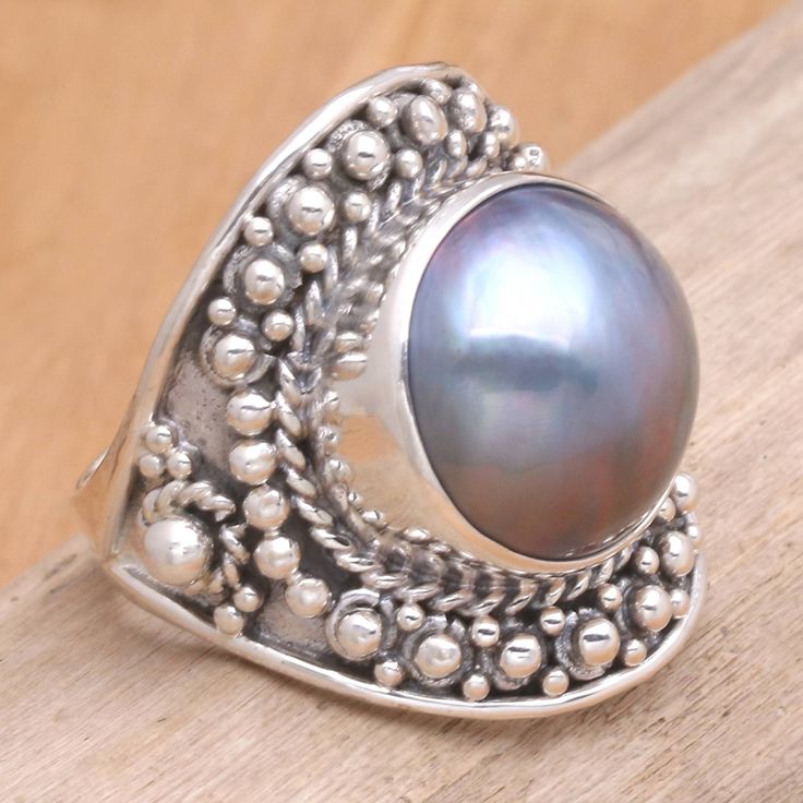 From Kadek Wijanegara, this pearl ring displays the opulence of traditional Balinese design. The sterling band is covered with tiny silver globes. The rich glow of a Mabe pearl hemisphere centers the dramatic ring. .925 Sterling silver Unique Silver Oval Pearl Ring, Silver Rings With Pearl Drop, Silver Pearl Drop Ring, Silver Pearl Ring With Pearl Drop, Heirloom Silver Oval Pearl Ring, Traditional Round Pearl Ring For Gift, Heirloom Style Pearl Ring Gift, Heirloom Pearl Ring As A Gift, Traditional Pearl Ring Gift