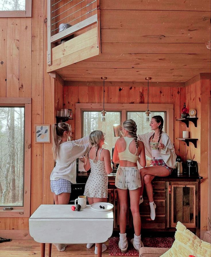 three girls are standing at the kitchen counter