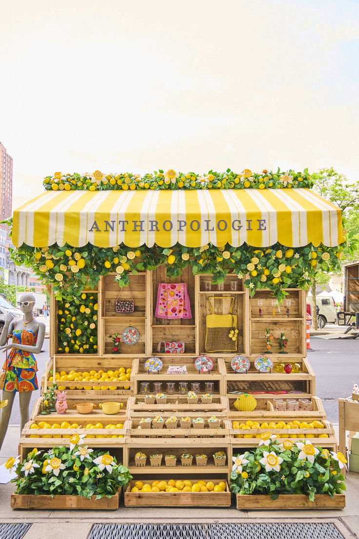 an outdoor fruit stand with lemons, oranges and other fruits on display in wooden crates