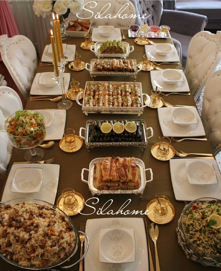 a long table with many plates and silverware on it that has food on it