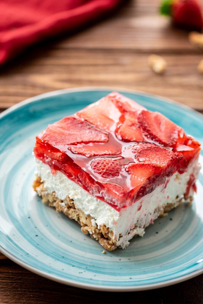 a piece of cake with strawberries on top is sitting on a blue and white plate