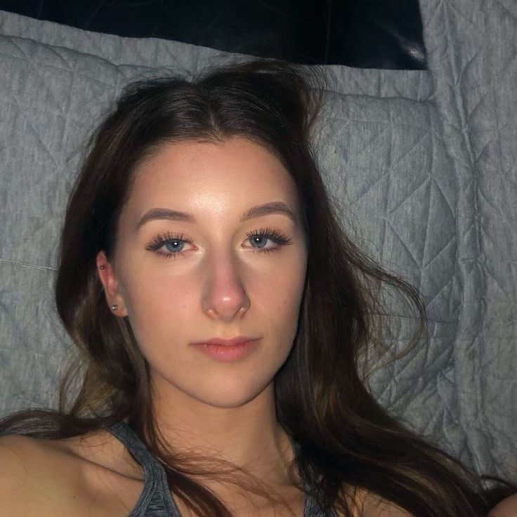 a woman laying in bed looking at the camera