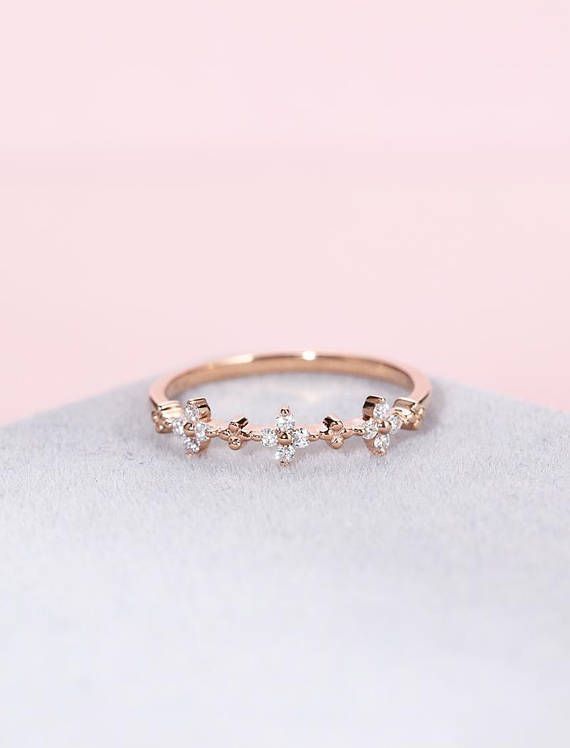 a gold ring with three small diamonds on the side, sitting on top of a white cloth