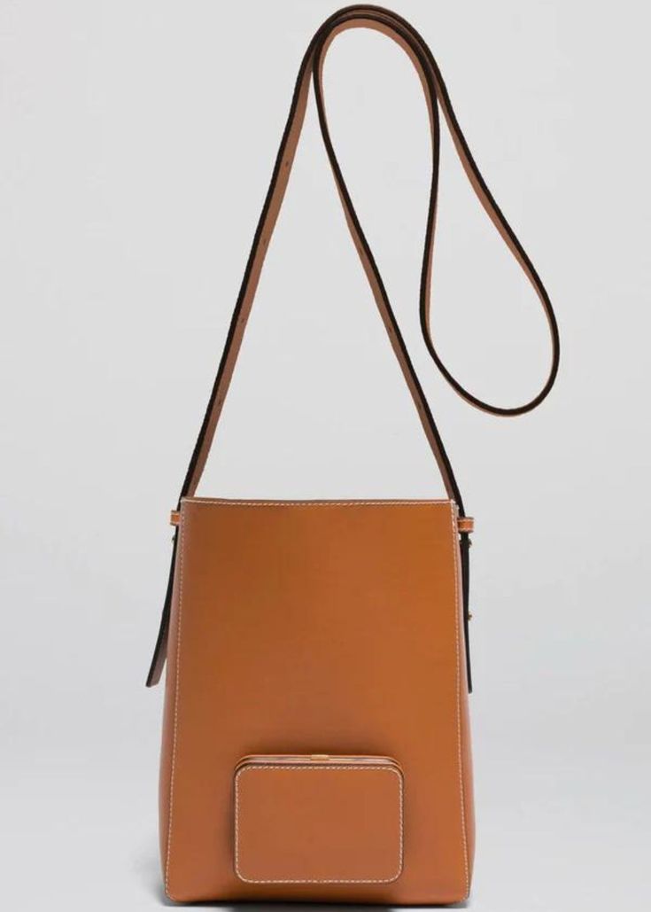 The Lutz Morris Parker M Soft in Tan is the ideal everyday bag for those on the go. With a spacious yet soft construction, it can easily fit all of your daily essentials. The adjustable strap and 24k gold-plated stainless steel frame make it comfortable to wear cross-body or on the shoulder. Additionally, the outside pocket features two leather slots to keep your cards, cash, and other essentials secure. Available in Tan Gold-rated smooth calf leather, tanned in Germany Frame is 24k gold-plated Luxury Tan Bucket Bag For Everyday Use, Luxury Tan Shoulder Bag For On-the-go, Luxury Tan Shoulder Bag For Everyday, Luxury Tan Crossbody Bucket Bag, Designer Tan Bucket Bag For Everyday, Modern Rectangular Bucket Bag With Gold-tone Hardware, Rectangular Bucket Bag With Gold-tone Hardware For Everyday Use, Designer Everyday Bucket Bag With Adjustable Strap, Modern Bucket Bag With Gold-tone Hardware For Travel