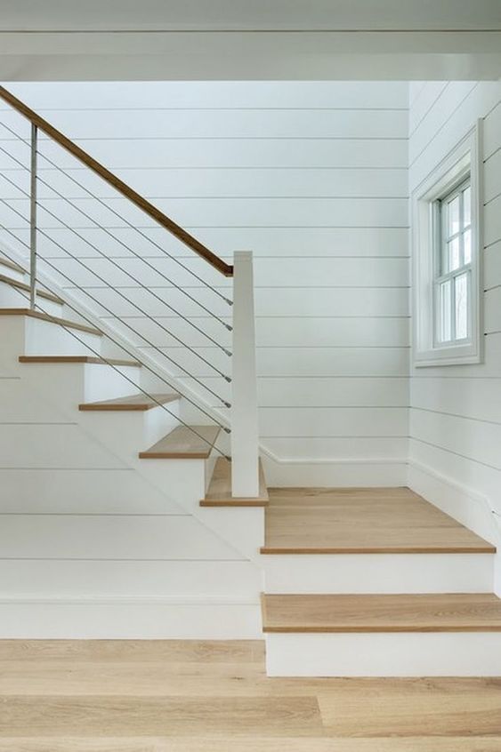 an empty room with white walls and wooden stairs