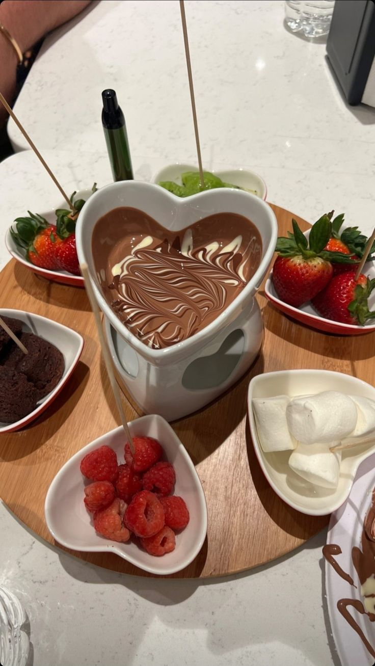 chocolate fondant, strawberries, and marshmallows are arranged in heart shaped bowls