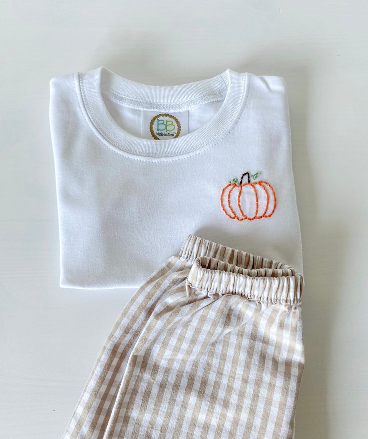 Hand embroidered pumpkin t shirt! If you need your item quicker please message and I'll be happy to accommodate! Follow my Instagram for more! stitchedxalicia Smiley Face Embroidery Design, Hand Embroidered Pumpkin, Newborn Embroidery Clothes, Hand Embroidery Pumpkin, Pumpkin Embroidery Designs, Hand Embroidered T Shirt, White T-shirt With Custom Embroidery For Fall, Custom Embroidered White T-shirt For Fall, White Custom Embroidered T-shirt For Fall