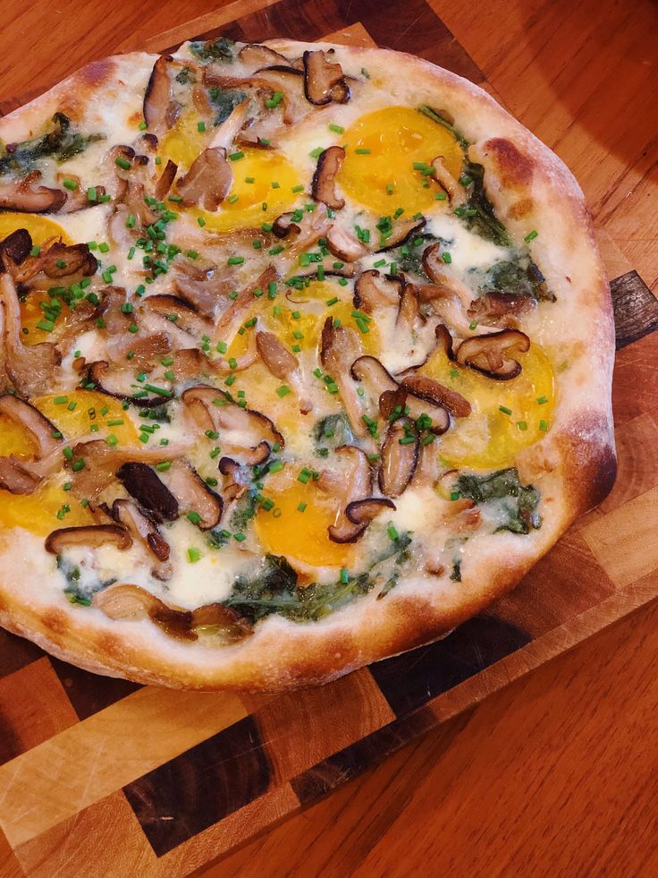 a pizza sitting on top of a wooden cutting board covered in cheese and toppings