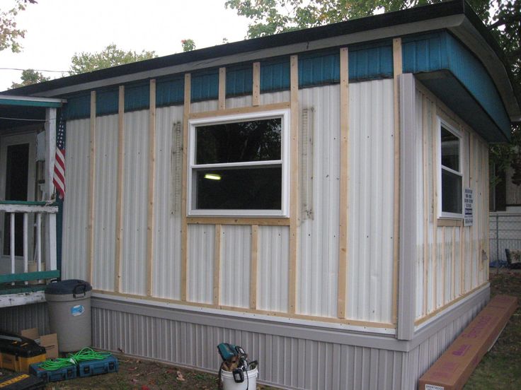 a small house that is being built with siding on the side and windows in place