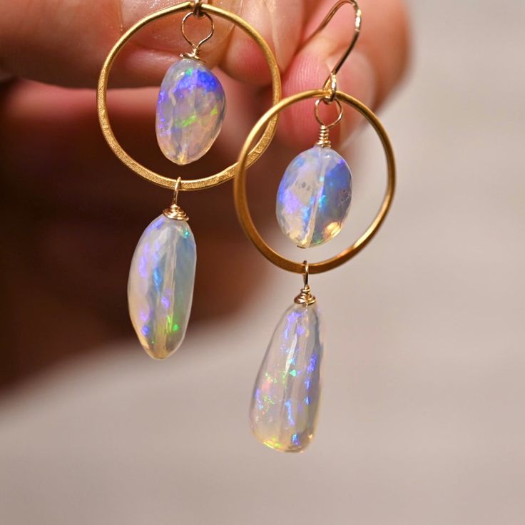 Atlantis Drops earrings are made woth gorgeous opals that look like they were formed from the magical waters of Atlantis. These opals display a blue hue with a rainbow flash inside. These have 4 spectacular opals and fhey are accenting with the finest gold vermeil hoops. Golden Circles - Gold Vermeil (over .925 sterling silver) Ethiopian Opals Top Opals: 12 x 9 mm Large Bottom Opals: - 18 x 9 mm 14 K Gold Filled Ear Wire Length: 2” Celestial Opal Gemstone Jewelry, Celestial Iridescent Dangle Jewelry, Iridescent Celestial Dangle Jewelry, Oval Opal Jewelry With Matching Earrings, Opal Jewelry In Yellow Gold With Matching Earrings, Yellow Gold Opal Jewelry With Matching Earrings, Unique Iridescent Opal Jewelry, Iridescent Opal Round Jewelry, Iridescent Round Opal Jewelry