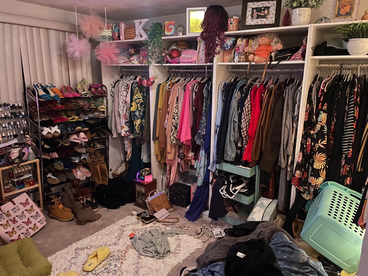 a closet filled with lots of clothes and other items on shelves next to a window