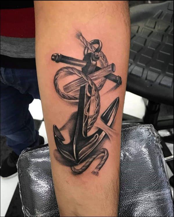 a black and white anchor tattoo on the leg