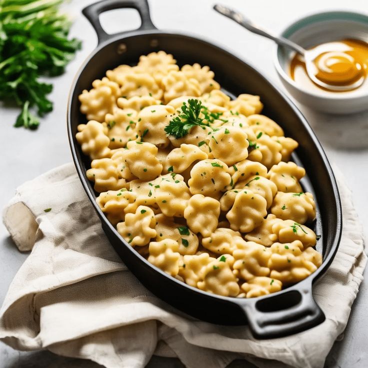 a skillet filled with macaroni and cheese on top of a white table