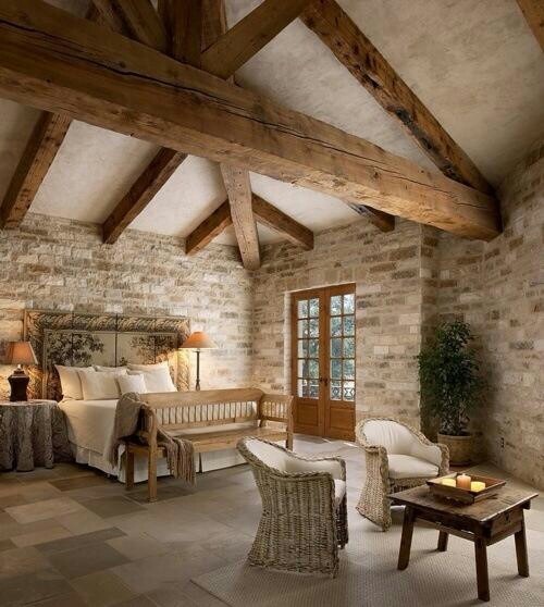 a bedroom with stone walls and exposed beams