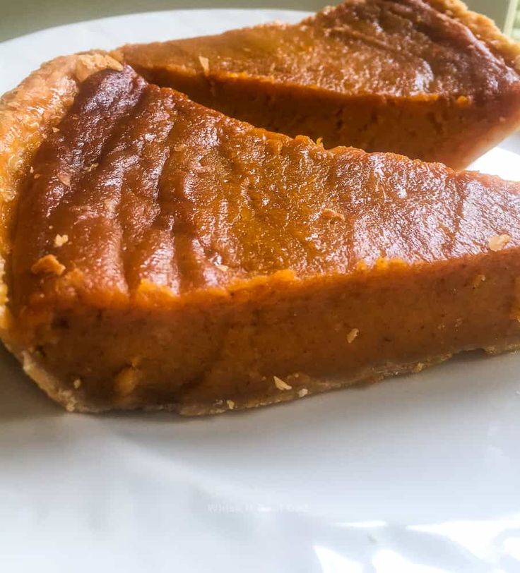 two slices of pumpkin pie on a white plate