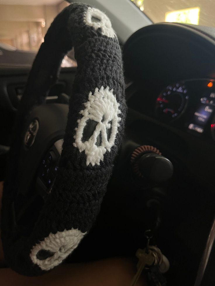 a steering wheel cover with a crocheted skull and crossbones on it