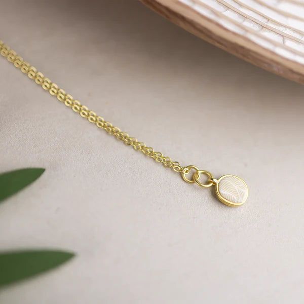 Lift Your Look with Soft Tones and Breezy Colors Complement your accessory collection with our Jilzarah Ivory Palm Petite Coin Necklace. Featuring light and breezy colors, this necklace brings a touch of sophistication to any outfit. The double-sided polymer clay inlays are beautifully set in a gold-plated coin-sized bezel that set of its soft tones and delicate patterns. Its versatile design allows you to wear it with various styles and for any occasion. Add this chic piece to your jewelry box Elegant Long Beige Necklace, White Necklace With Delicate Chain For Her, Elegant Adjustable Beige Necklace, Adjustable Cream Necklace, Beige Jewelry With Adjustable Length For Gift, White Necklace With Adjustable Length For Gifting, White Necklace With Adjustable Length For Gift, White Necklace With Adjustable Chain As Gift For Her, Beige Adjustable Length Jewelry For Gift